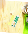 Drywall Repair Putty Paste For Quick Hole Patching And Wall Mending Cream next to painter's tools on wooden surface