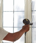 Person using hairdryer on Winter Window Insulation Kit With Roll Shrink Film That Covers Up To 15 Windows Measuring 3 By 5 Feet Tape Included No Brainer Easy Install Clear Draft Blocker For Energy Savings No Measuring Needed 15 Pack.