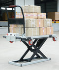 No Sweat Hydraulic Scissor Lift Platform And Portable Flatbed Dolly With Four Heavy Duty Swivel Wheels Built For Easy Shop Tasks And Smooth Transport Up To 440 Pound Capacity loaded with boxes in warehouse.
