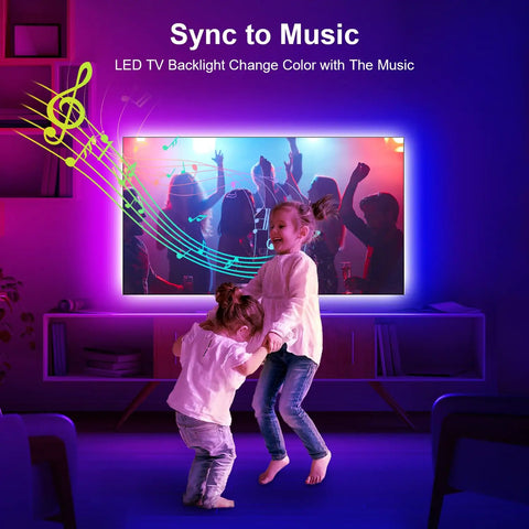 Children dancing in front of TV with 6.56ft RGB LED Backlight Strip For 24-30 Inch TVs, Easy Corner Install Behind Screen, USB Powered 5V, App Remote Control And Music Sync, 16 Million Color Ambience, Ideal Bedroom, PC, And Game Console Setup.