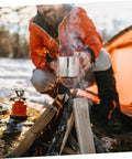 Camping scene with 8 Piece Portable Stainless Steel Camping Cookware Set With Fire Resistant Pots And Bowls by a campfire