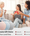Three women happily exchanging gifts on a sofa with gift boxes and presents in the foreground, promoting gift choices for special occasions.