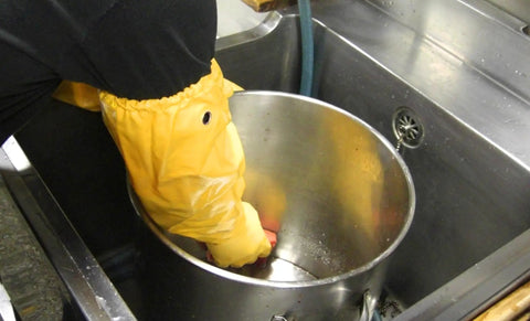 Atlas 772 Double Nitrile Coated Full Arm Chemical Resistant Safety Glove With Cotton Poly Liner being used to wash a large metal container