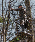 Hunter using Titan Sd Climbing Treestand With Roomier Design Bigger Top Seat Frame And Longer Foot Platform For Large Frame Hunters
