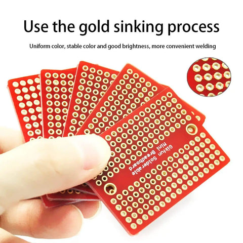 Hand holding a pack of five Mini Solderable Breadboard With Gold Plated Finish Proto Board For Arduino And DIY Electronics 1.3 By 1.8 Inch
