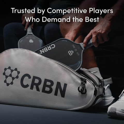 Person placing carbon fiber pickleball paddle into CRBN bag, "Trusted by Competitive Players" text displayed above