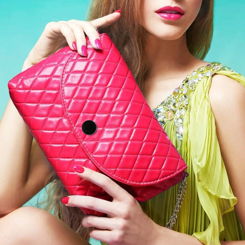 Woman holding pink quilted clutch bag with black snap, wearing yellow dress