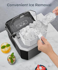 Front view of a black Silonn countertop ice maker with a transparent lid, white ice basket full of ice cubes and scoop