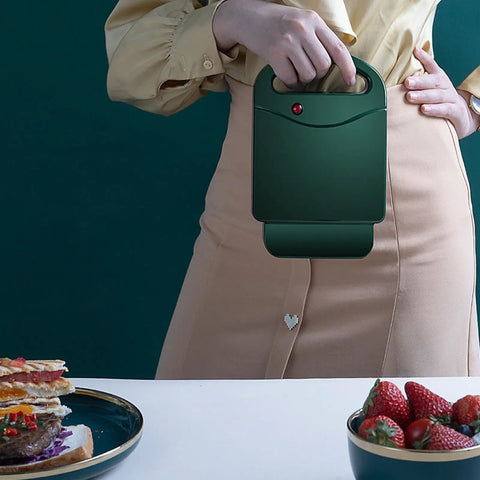 Compact Electric Sandwich Maker And Grill Press For Perfect Grilled Cheese held in hand, showcasing easy portability and sleek design.