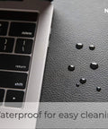 Pebble Black Leather Desk Mat With Cable Organizer 35 By 17 Inches, Premium Vegan PU Desk Pad And Mouse Mat, Felt Desk Protector shown with water droplets and keyboard.