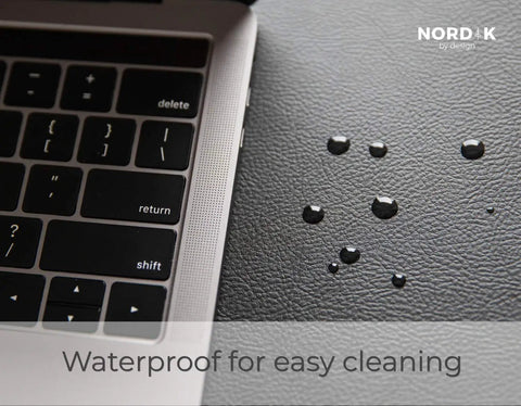 Pebble Black Leather Desk Mat With Cable Organizer 35 By 17 Inches, Premium Vegan PU Desk Pad And Mouse Mat, Felt Desk Protector shown with water droplets and keyboard.