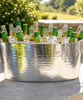 Armored XL Insulated Beverage Tub For Parties, Double Wall Stainless Steel Ice Bucket filled with bottles outdoors