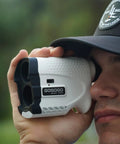 Person using Bang For Your Buck Budget Friendly Golf And Hunting Rangefinder With Seven X Magnification, 1200 Yard Distance