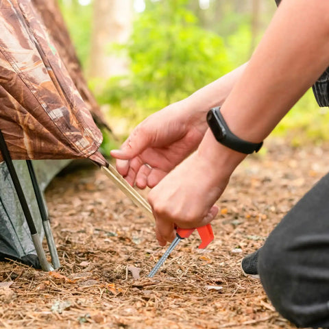 Rock Solid Heavy Duty Metal Tent Stakes Set With 7.87 Inch Screw In Pegs And Plastic Rotating Heads in use securing a tent