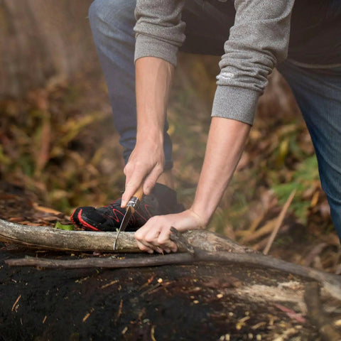 User demonstrating Badass Lightweight Folding Saw For Weekend Campouts And Garden grinding branch with carbon steel blade.