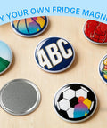 Colorful custom magnets from 58mm Fridge Magnet DIY Kit Pack of 100 Sets with metal covers, clear film, and blank paper on wooden surface.
