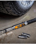 One Quarter Inch Drive 120XP Flex Head Electronic Torque Wrench With Angle Readout beside tire on concrete floor
