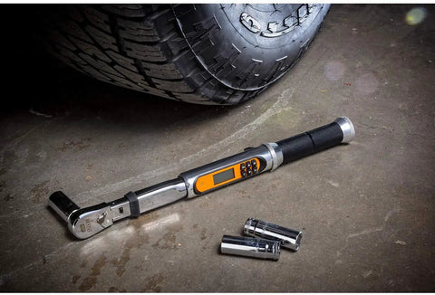 One Quarter Inch Drive 120XP Flex Head Electronic Torque Wrench With Angle Readout beside tire on concrete floor