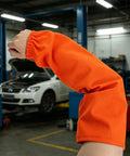 No Sweat Flame Resistant Welding Sleeves With Adjustable Cotton Fit shielding mechanics from sparks, vivid orange color, detailed shot.