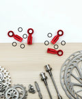Top Aluminum Alloy Hydraulic Hose Fittings And A Pair Quick Connect Couplers For Bike Disc Brakes Gives Tight Seam Fit With A Dope Red Finish For Super Reliable Braking Grip And Sick Style That Keeps Everything Fresh For Riding Like A Boss Anytime. Red alloy bike brake hose connectors and O-rings on a tabletop
