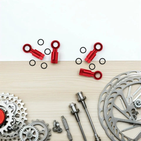 Top Aluminum Alloy Hydraulic Hose Fittings And A Pair Quick Connect Couplers For Bike Disc Brakes Gives Tight Seam Fit With A Dope Red Finish For Super Reliable Braking Grip And Sick Style That Keeps Everything Fresh For Riding Like A Boss Anytime. Red alloy bike brake hose connectors and O-rings on a tabletop
