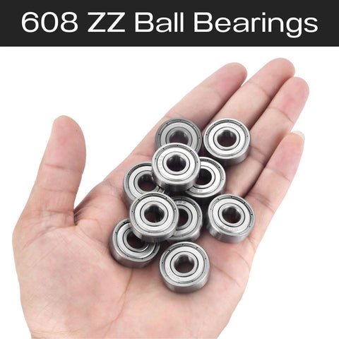 Hand holding about 12 608ZZ ball bearings, 8x22x7 mm, shielded steel.