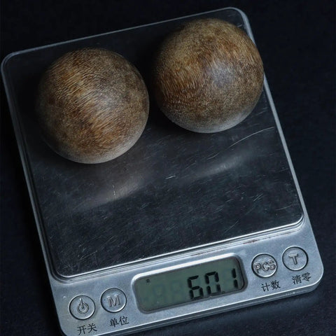 Two agarwood spheres on a digital scale. Dope Vietnam Nha Trang Agarwood White Aquilaria Old Growth Raw Material For Carving.