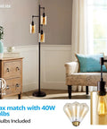 Three-Head Industrial Farmhouse Floor Lamp with Amber Glass Shades in living room setup with sofa and wooden dresser