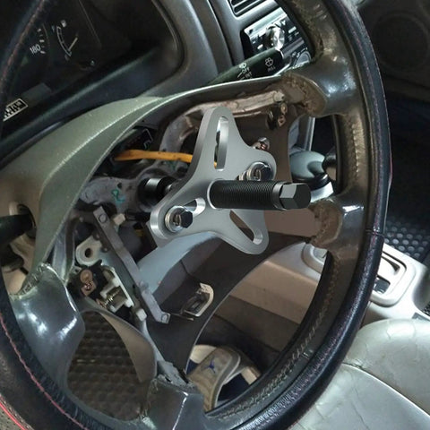 46 Piece Steering Wheel Puller Kit for Harmonic Balancers, Crank Pulleys, Gears and 4 Way Slotted Puller shown in use on steering wheel.