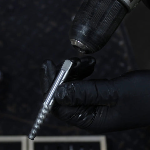 Jumbo Spiral Flute Bolt And Screw Extractor Set 9 Piece with square shank held by gloved hand near drill