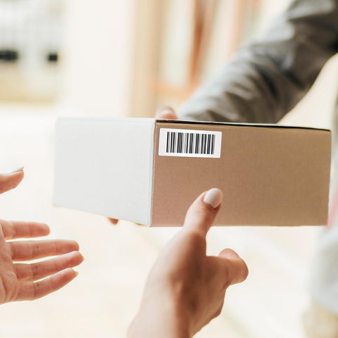 Heavy Duty Thermal Transfer Shipping Labels 2 X 1 Inches on a cardboard box during delivery, showing barcode and clear labeling.