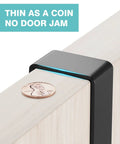 Close-up of no drill over the door mop and broom holder shown on door edge with coin for size reference. Thin as a coin, no door jam.