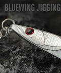 Close-up of High Impact Saltwater Fishing Jigs For Speed Jigging With Barbed Hooks And Solid Lead Core in shiny silver with red eye.