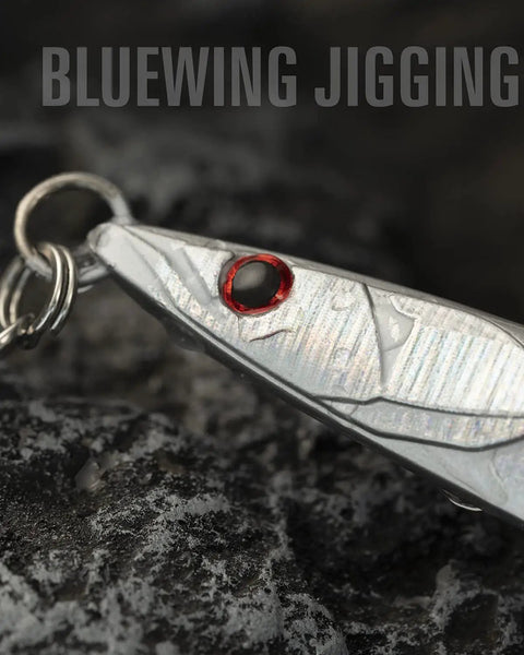 Close-up of High Impact Saltwater Fishing Jigs For Speed Jigging With Barbed Hooks And Solid Lead Core in shiny silver with red eye.