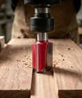 Heavy Duty Straight Router Bit Featuring Heat Treated Tungsten Carbide Blades cutting through hardwood with shavings flying.