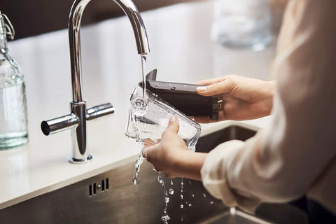 User rinsing the AquaClean cartridge of Fully Automatic Espresso Machine Featuring Intuitive Touch Display And Smooth LatteGo Milkmaker.