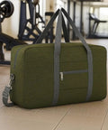 Go-To Foldable Travel Duffel Tote Bag Lightweight Carry On Personal Item for Women and Men Fits Underseat Airline Size 18x14x8 Inches Spirit Frontier Military Green No Shoulder Strap Included Durable Tear Resistant Gear displayed in gym setting.