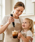 Woman using Rechargeable Milk Frother for Home Baristas With 1800mAh Battery, 9 Speeds And 3 Whisk Attachments to froth milk in a kitchen