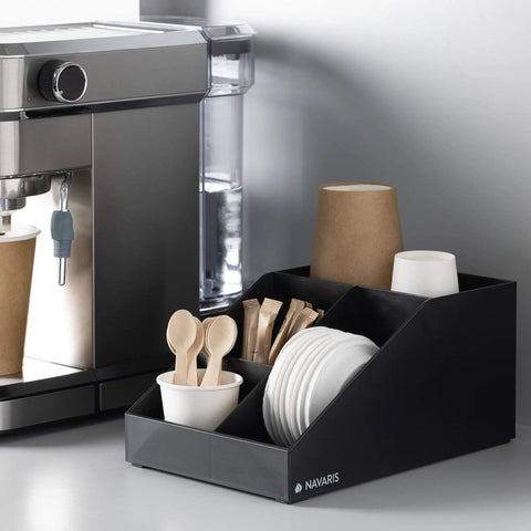 Coffee Station Organizer With 4 Compartments Perfect For Storing Coffee Pods Sugar Creamer Stirrers And Tea Bags On Your Office Or Kitchen Countertop For Quick Grab And Go Access And Neat Countertop Organization positioned next to coffee machine on counter.