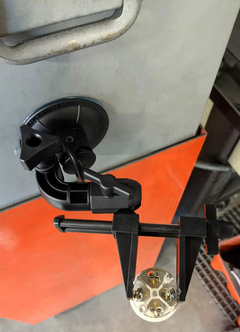 Kickass Vacuum Bench Vise For Smooth Workbenches With No Sweat Clamping Mechanism Featuring Low Key Tilt Rotate Knobs Beefy Grooved Jaws Perfect For Delicate Hobby Crafts And Circuit Repair Black mounted on a workbench with a suction base.