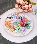 Forty Five Piece Rock Solid Metal Lobster Claw Clamps With Dope Mixed Color Combo, assorted colors displayed on a white plate.