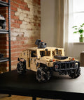technic RC Hummer kit assembled on a table in a room with a brick wall, showcasing its military-style design and detailed build.