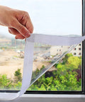 Ditch The Winter Chill With Adjustable Clear Window Insulation Kit Featuring Tough Adhesive Strips Reusable Plastic Film Wrap visible being applied to window