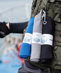 Grab And Go Clip On Microfiber Fishing Towels With Waffle Pattern in blue, grey, and black clipped to a green fishing vest.