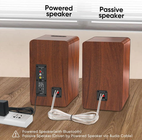 Back view of Bluetooth Bookshelf Speakers 40W X 2 with cable connections, showing powered and passive units on a wooden surface.