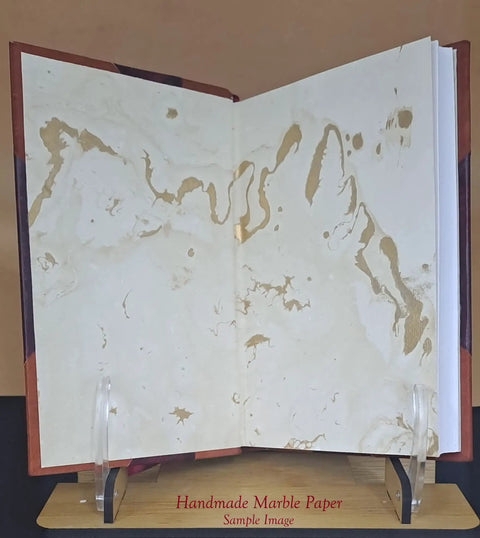 Open leather-bound manual displaying marbled paper texture on wooden stand, related to Fuel Injector Pump Tester Parts And Tools Reference Guide.
