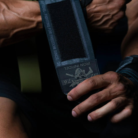18 Inch Heavy Duty Wrist Wraps For Weightlifting And Powerlifting With Ultra Strong Support For Bench Press, Deadlifts, Curls, CrossFit, And General Gym Workouts For Men being adjusted on wrist.