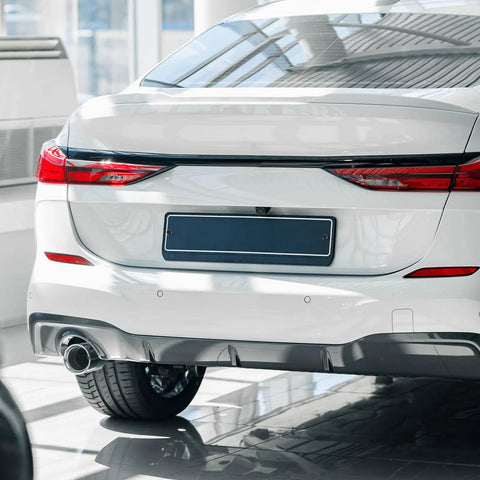 Rear view of a white car with a mounted black license plate, featuring Black License Plate Screw Cap Kit With Eight Caps For Frame Bolts.
