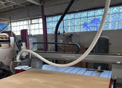 Shop Tested Heavy Duty Clear Flexible Dust Collection Hose 1 1/2 Inch By 20 Feet connected to CNC machine, used for dust removal.