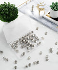 70 Pack Locking Pin Backs Metal Seals For Badges Brooches And Enamel Pins secure in transparent box on a marble table.